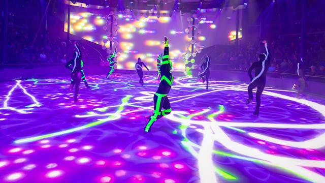 IC, Icon of the Seas, Ice Skaters performing at Absolute Zero while crowd watches, entertainment, performance, performers, show, lights, purple and green colors, day-glo green, arena,