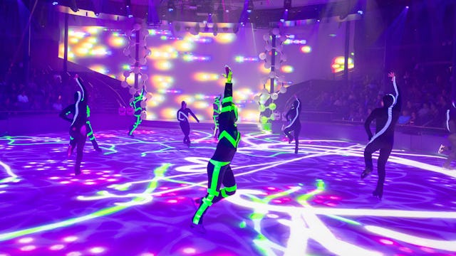 IC, Icon of the Seas, Ice Skaters performing at Absolute Zero while crowd watches, entertainment, performance, performers, show, lights, purple and green colors, day-glo green, arena,