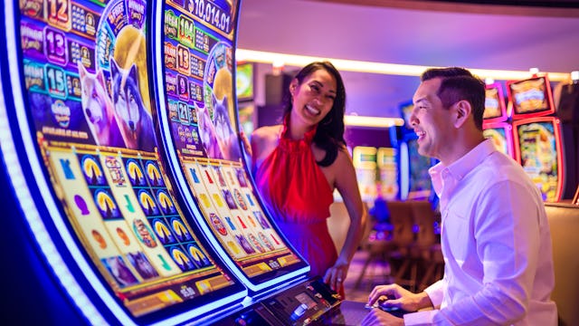 IC, Icon of the Seas, casino, couple at Casino Royale slot machine, fun, games, nightlife, excitement, anticipation,