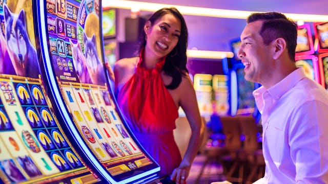 IC, Icon of the Seas, casino, couple at Casino Royale slot machine, fun, games, nightlife, excitement, anticipation,