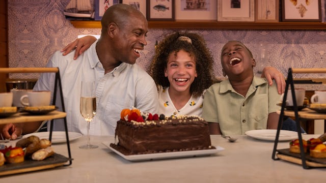 IC, Icon of the Seas, Dad and two kids celebrating together at Celebration Table in the AquaDome, family fun, laughter, VIP experience, decorated chocolate cake.