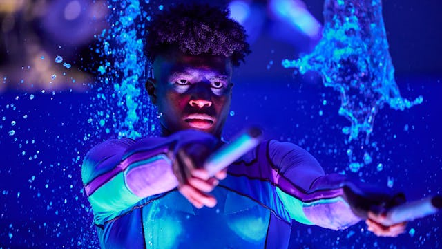 IC, Icon of the Seas, wide shot of performers, on stage in AquaTheater show. Aqua Action, fountains of water bubbling up, excitement, exciting, blue colors, stage lights,