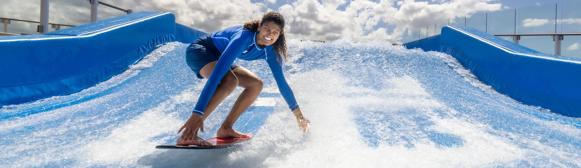 Surfing at the FlowRider® surfing simulator on Icon of the Seas.