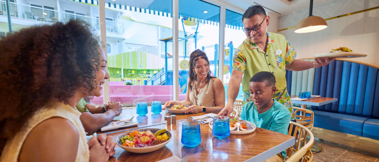 A family is being served by one of the staff members on board of the Icon of the Seas